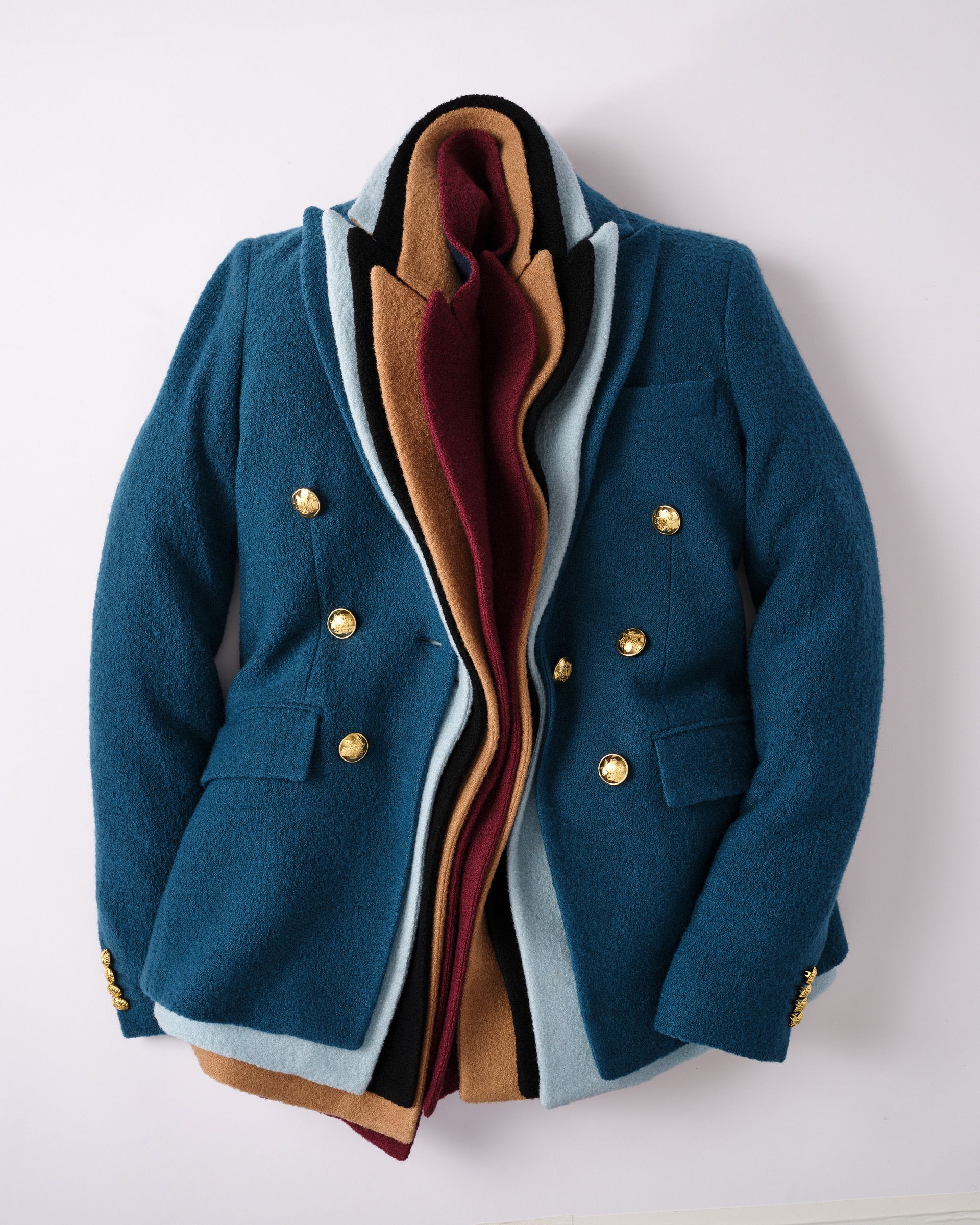 Teal blue blazer with gold buttons, revealing nested layers of light blue, black, tan, and maroon fabric.