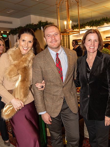 Three people posed together at a festive holiday party