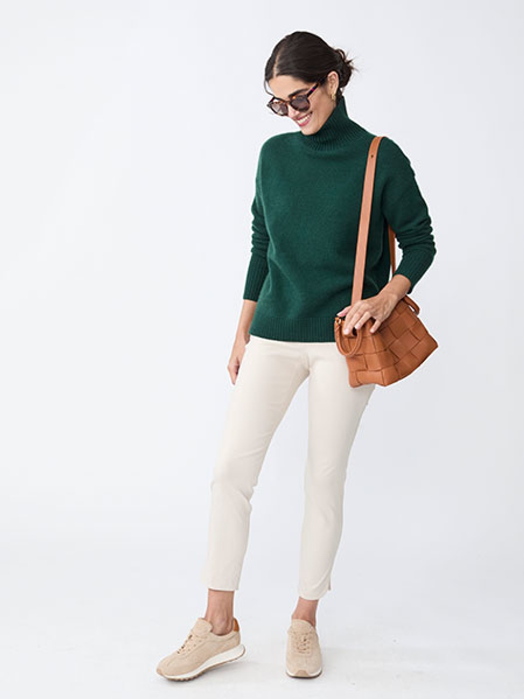 Model in cashmere turtleneck, pants, and sneakers Model in cashmere turtleneck, pants, and sneakers