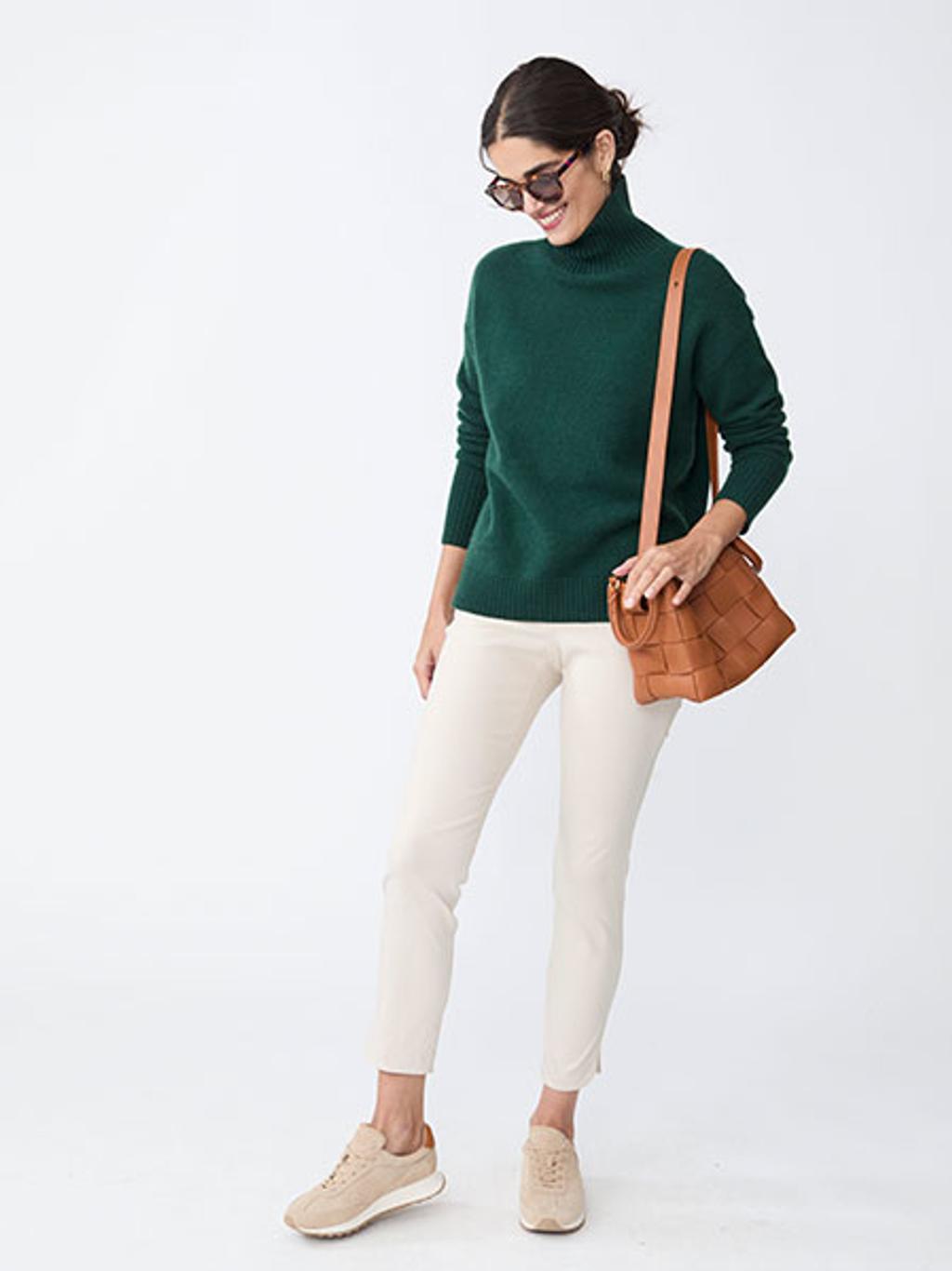 Model in cashmere turtleneck, pants, and sneakers Model in cashmere turtleneck, pants, and sneakers