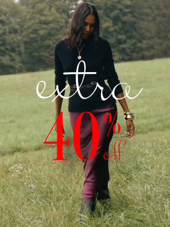 woman outside in grass wearing silky burgundy skirt and black turtleneck
