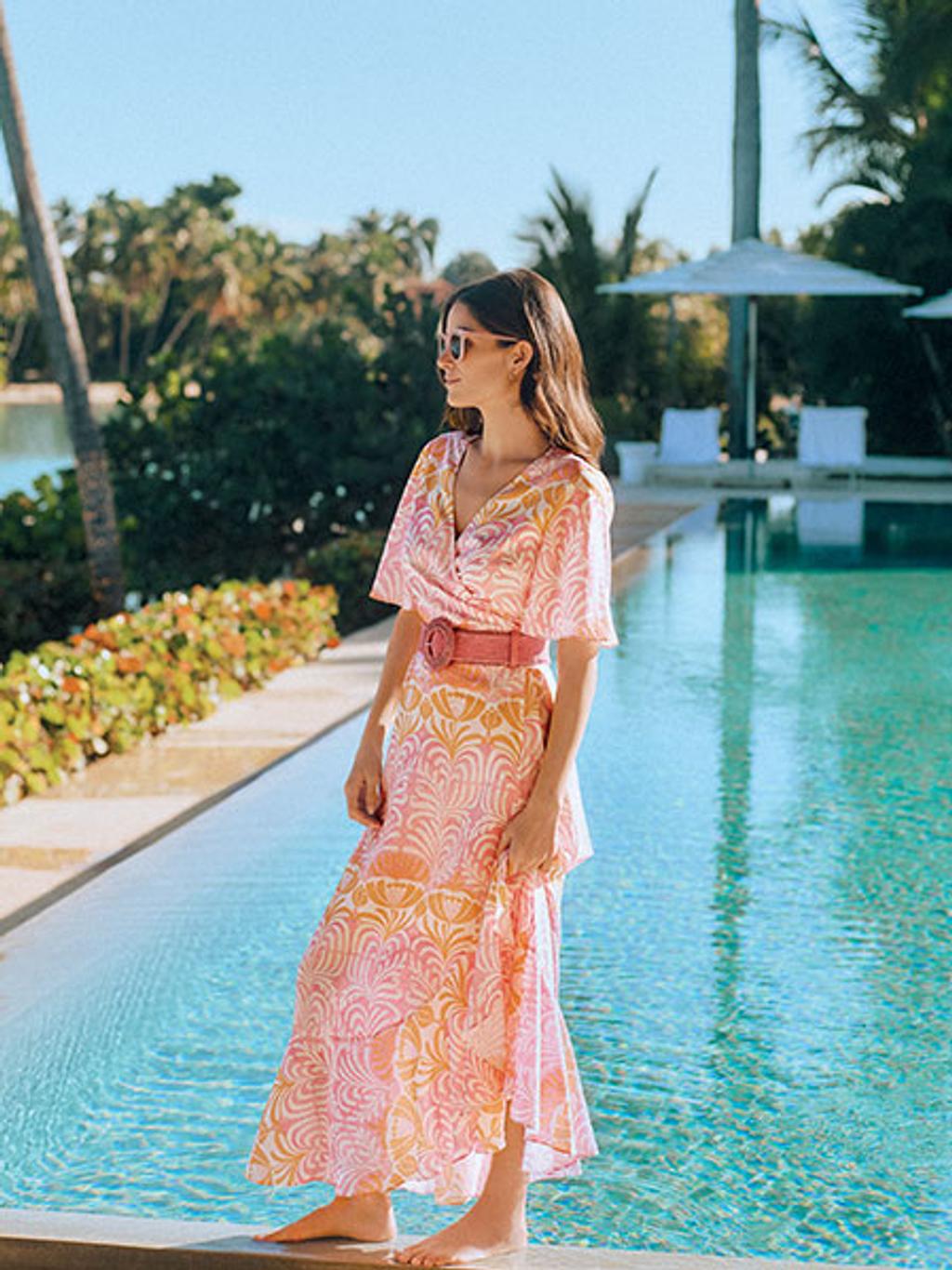 Model in pink palm-print maxi dress by pool