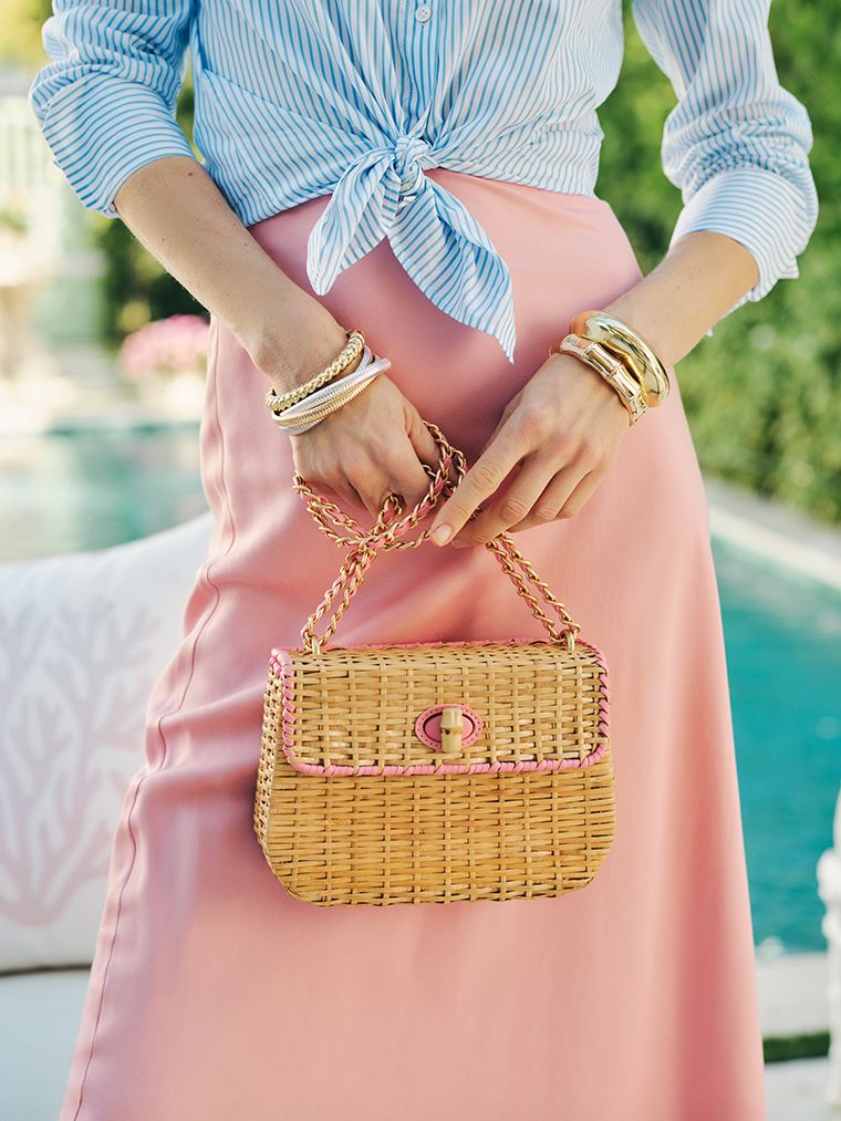 close up image of women holding wicker handbag.