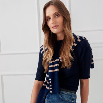 cropped in image of woman wearing navy half sleeve ribbed fine knit sweater with striped sweater tied around shoulders