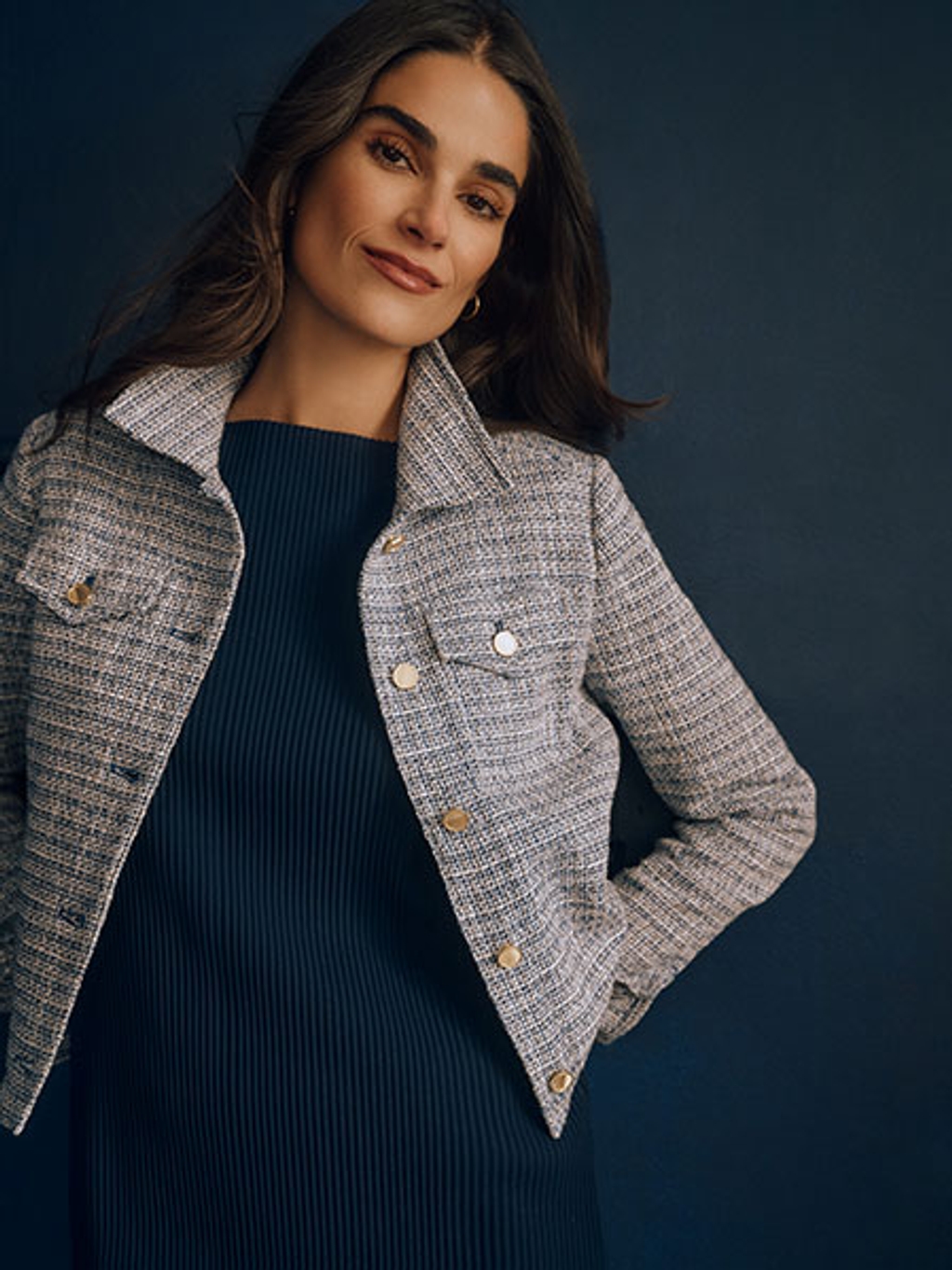 Model wearing a black top and tweed jacket