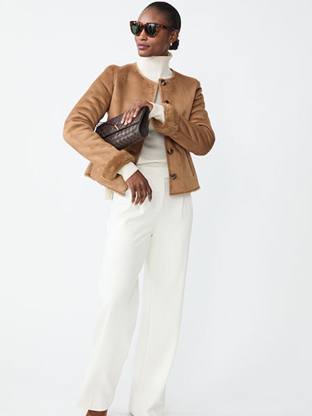 Model in off-white turtleneck, off-white pants, and faux shearling jacket