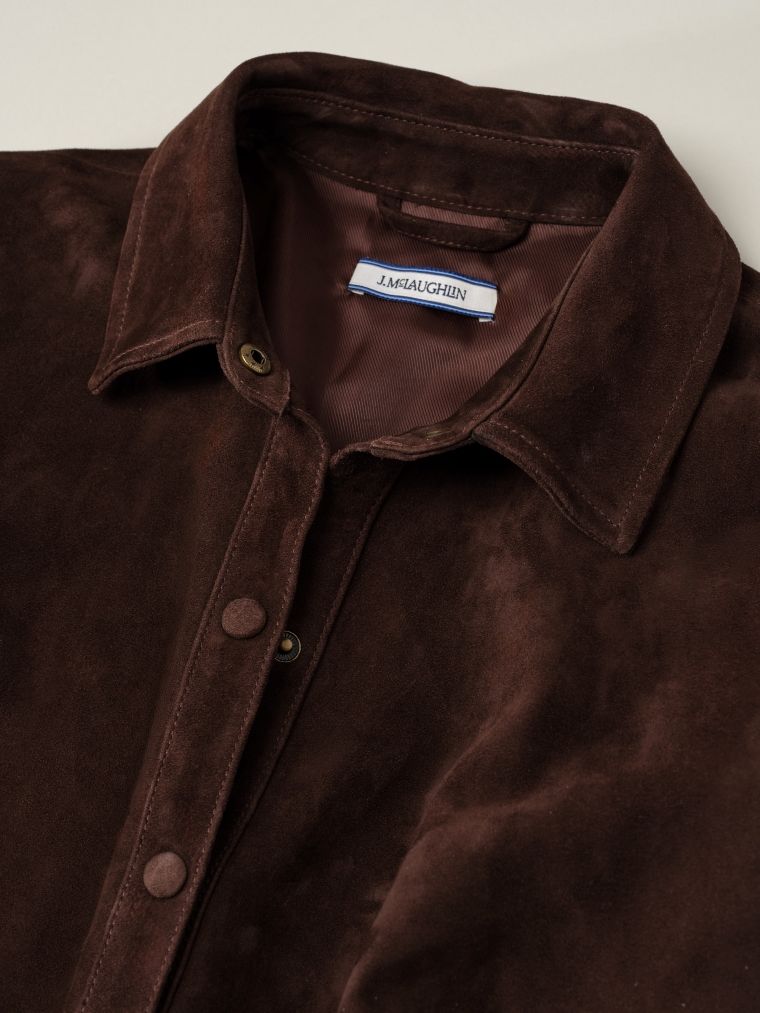 Close-up of a dark brown suede shirt with a J.MCLAUGHLIN label.
