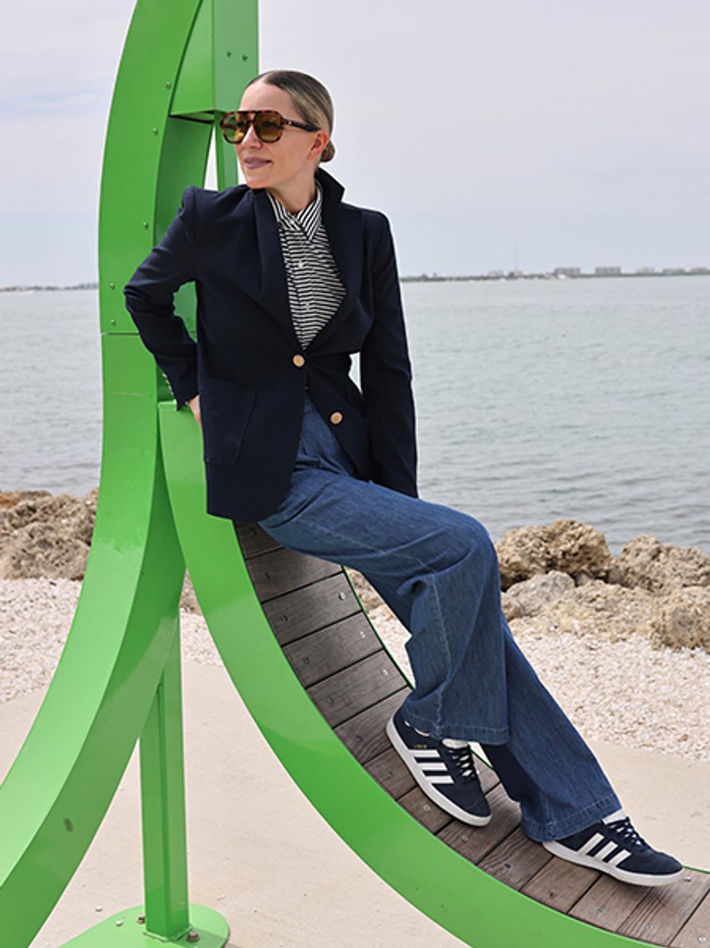 Blair Eadie wearing wide-leg pants, striped button down, and blazer.
