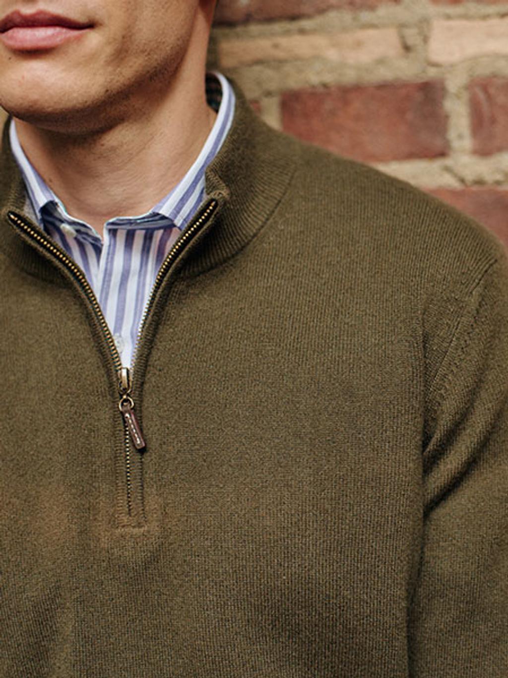 Model wearing a green quarter zip sweater.