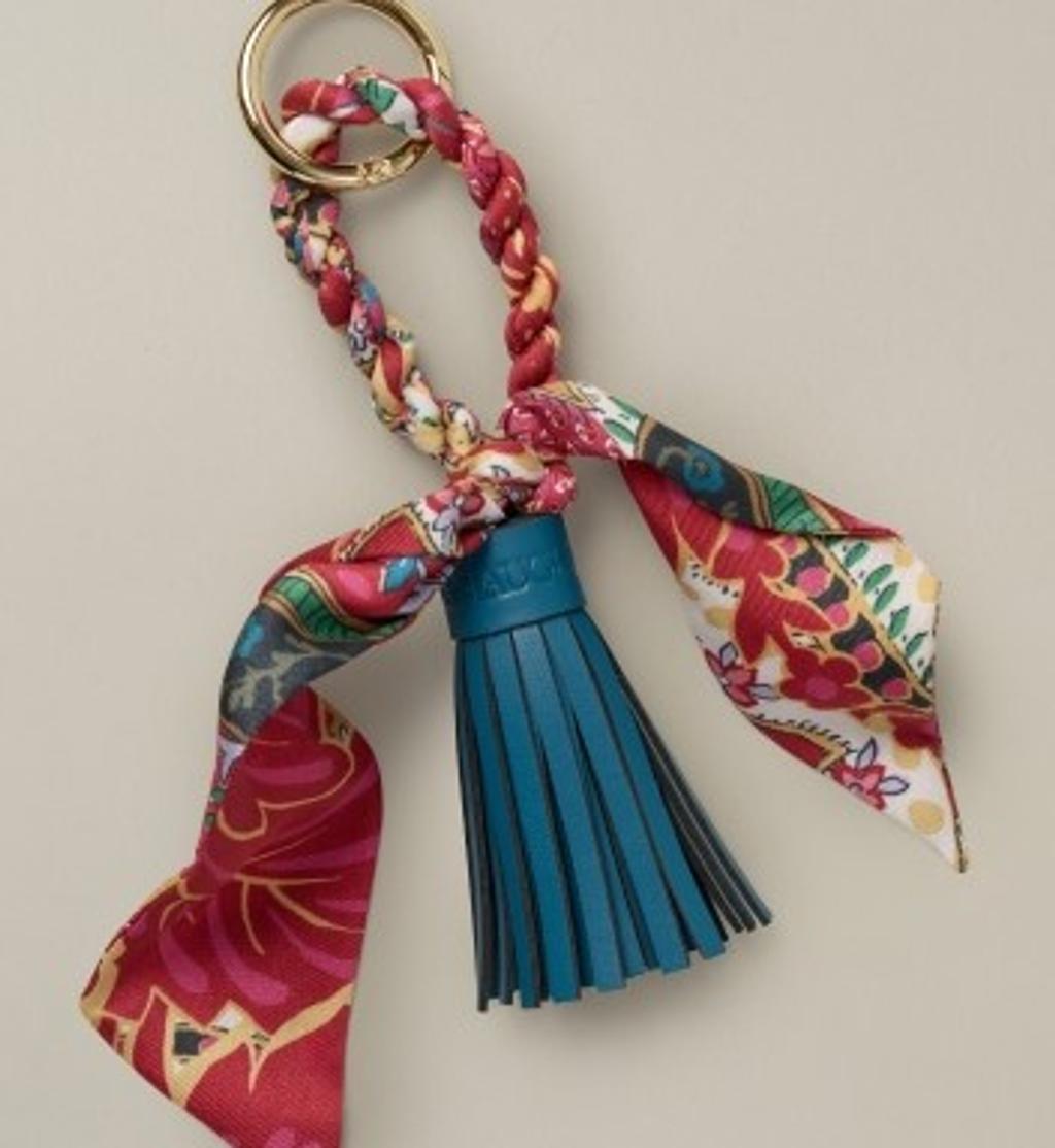Colorful patterned fabric keychain with a gold ring and teal leather tassel.