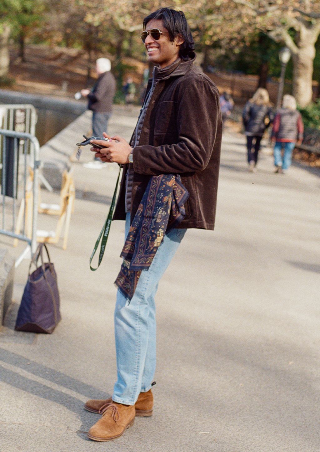 Male model modeling wearing button down shirt with sweater around shoulders 