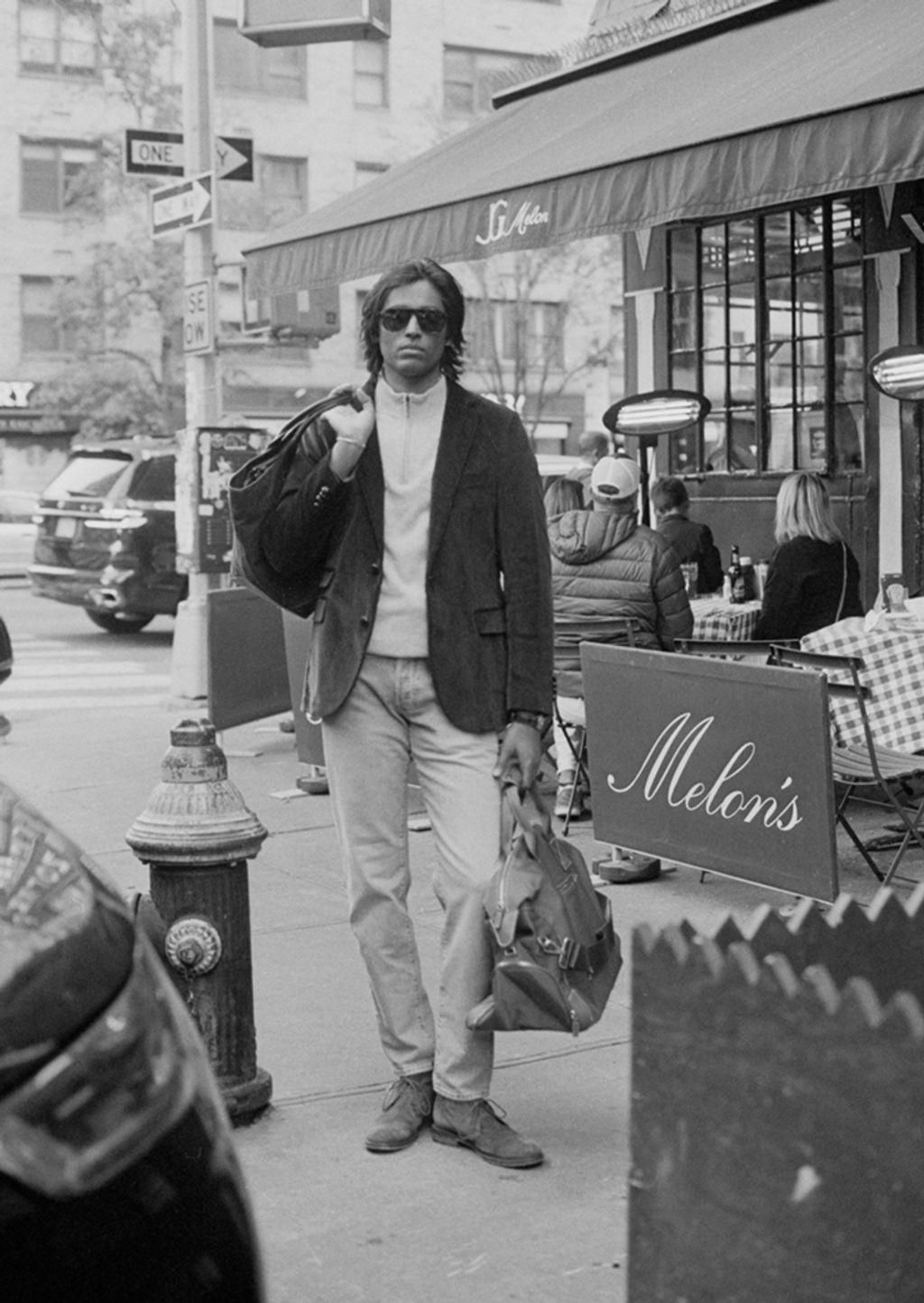 Male model modeling wearing button down shirt with sweater around shoulders 