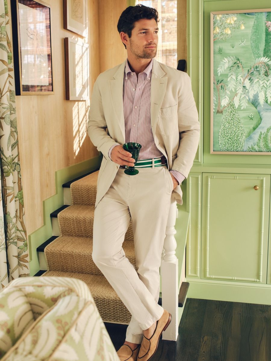 man standing in living room wearing light khaki suit