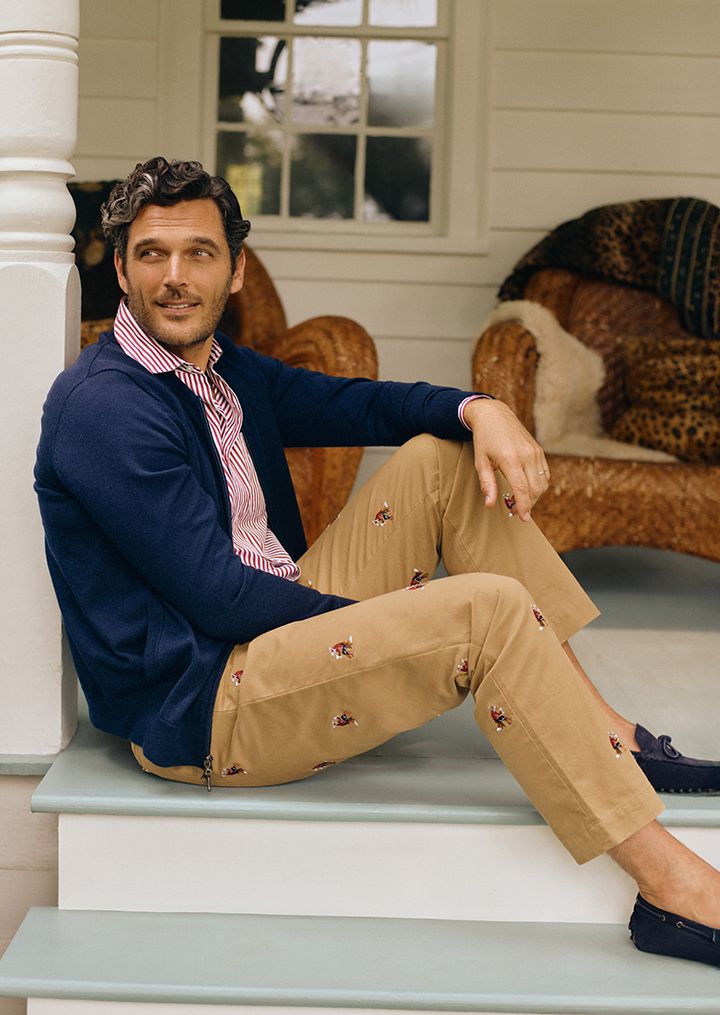 man sitting on porch in khaki embroidered chino pants