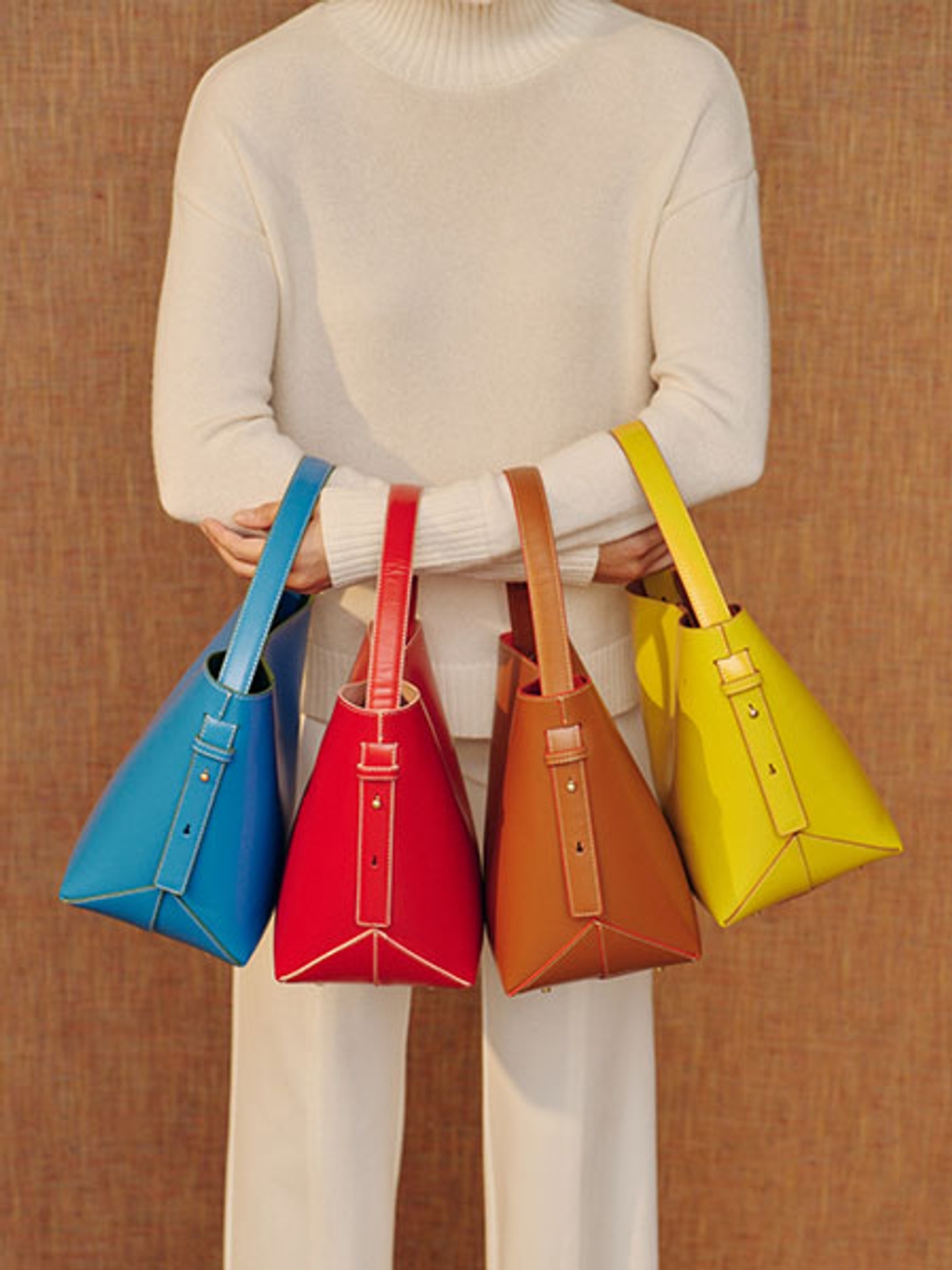Model holding colorful bucket bags