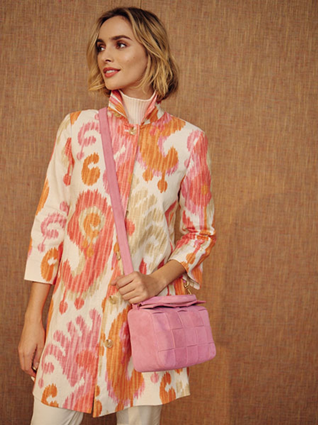Model in ikat coat with crossbody bag