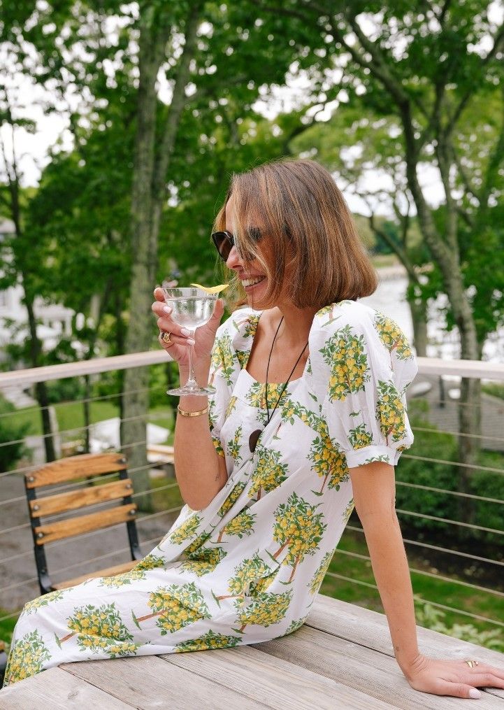 woman seated wearing a lemon patterned dress