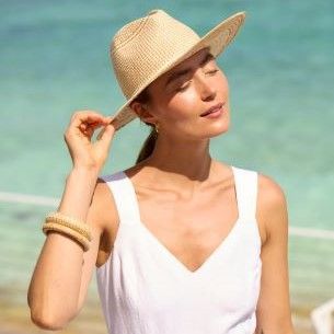 woman on beach in natural paper straw hat