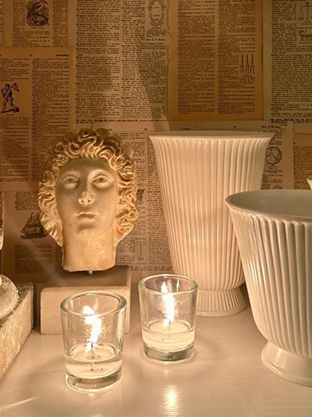 Tabletop vignette with votives, vases, and bust