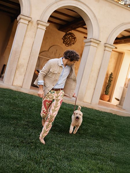 Model playing with dog on lawn