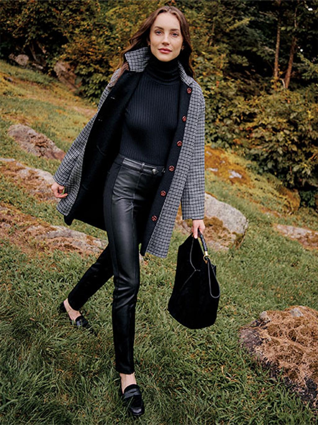 Model wearing plaid coat, turtleneck, and faux leather leggings