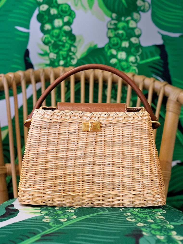 close up image of leather and wicker handbag sitting on a printed chair