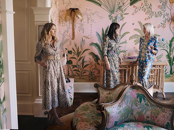 Three female models in various outfits, interior of a home