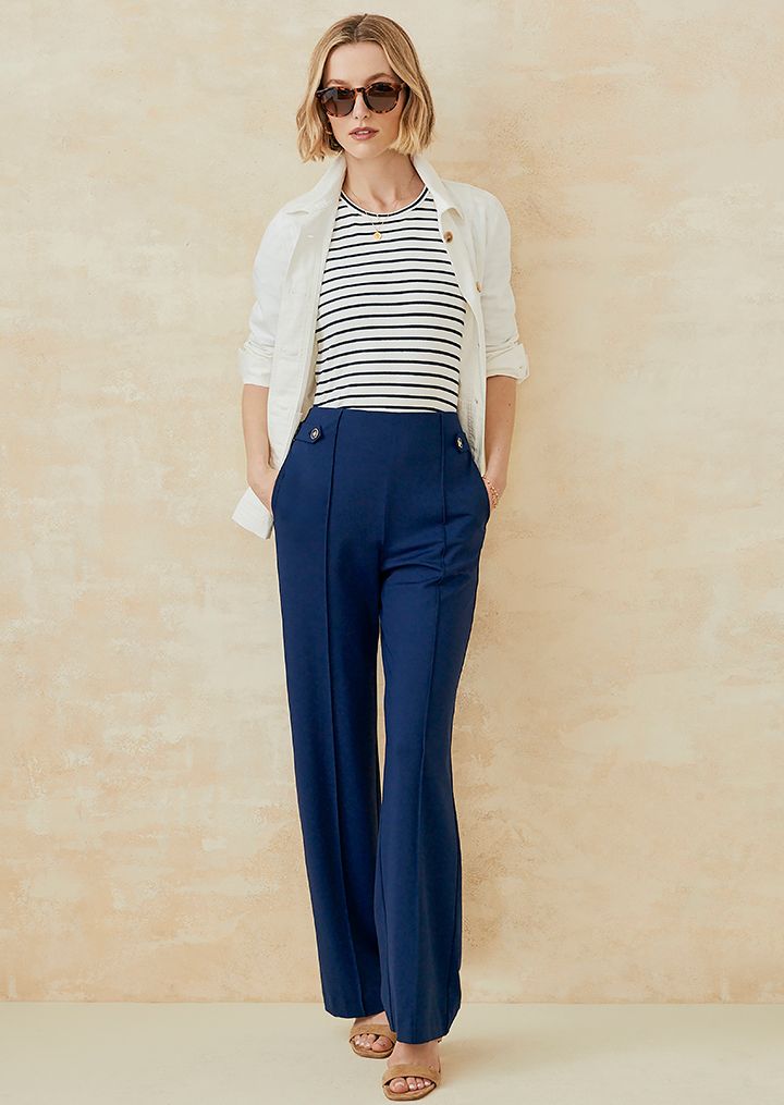 Woman standing in navy wide leg pants and blue striped tee. 