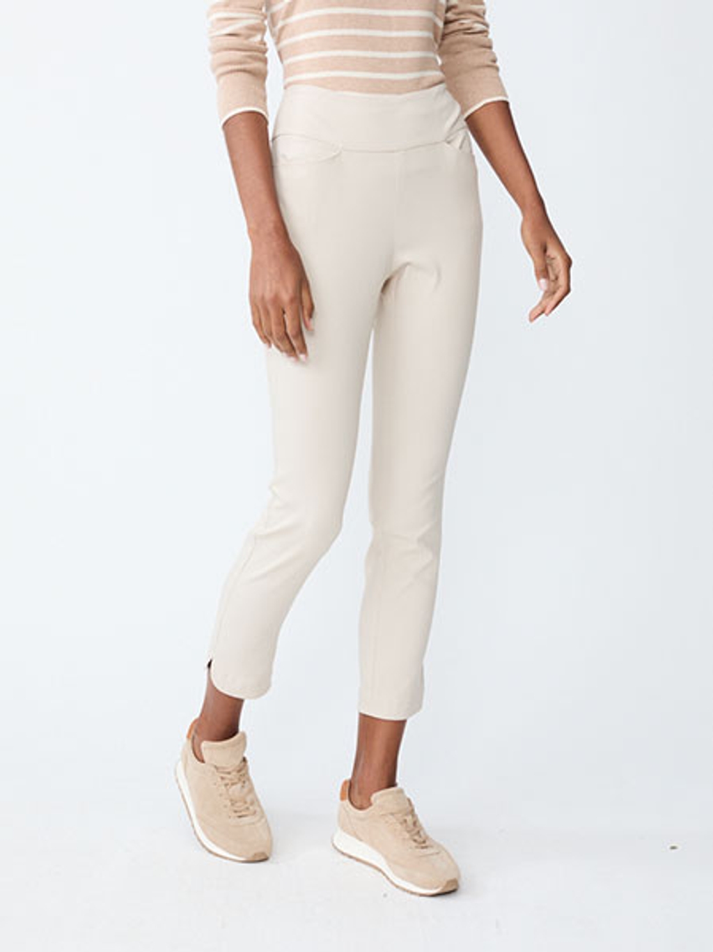Women wearing a tan and white striped shirt, white pants, and tan suede sneakers.
