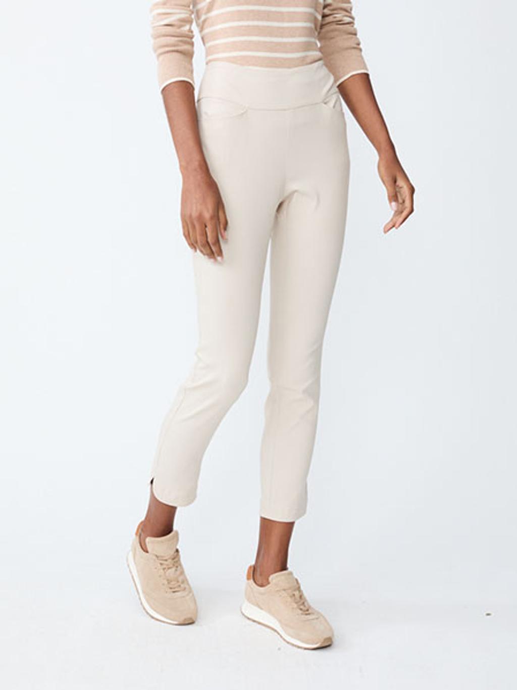 Women wearing a tan and white striped shirt, white pants, and tan suede sneakers.