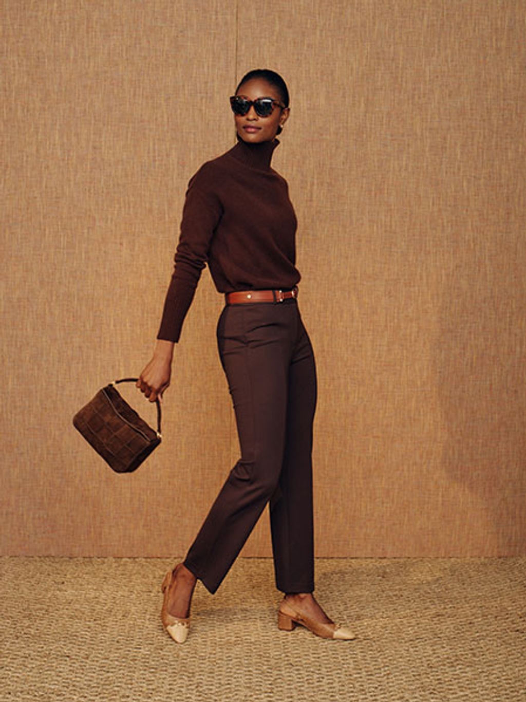 Model with brown crossbody bag, turtleneck, and pants