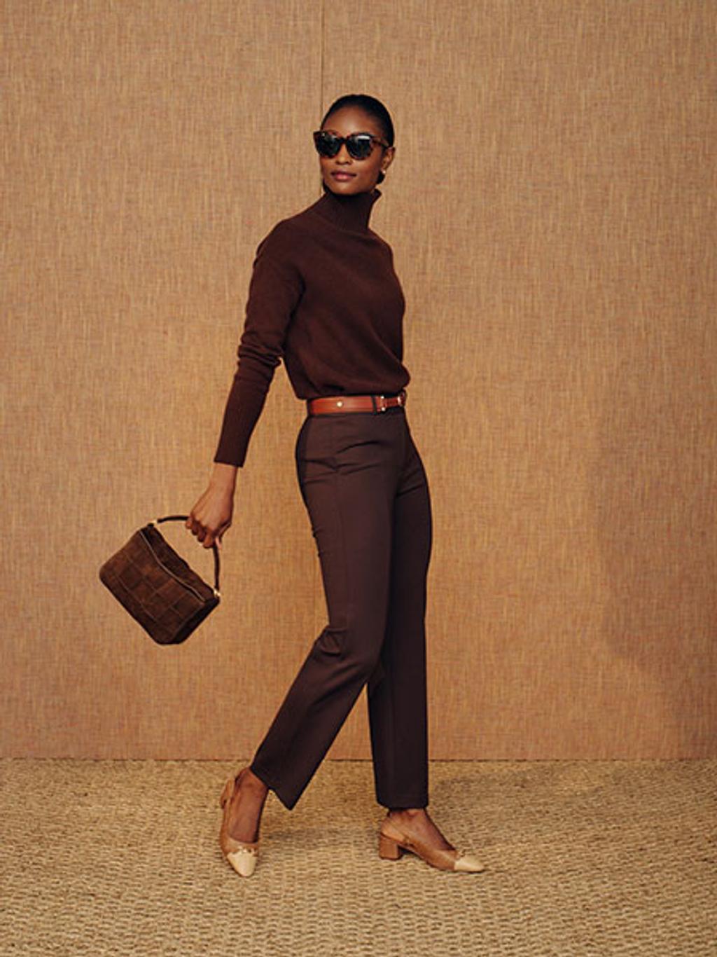 Model with brown crossbody bag, turtleneck, and pants
