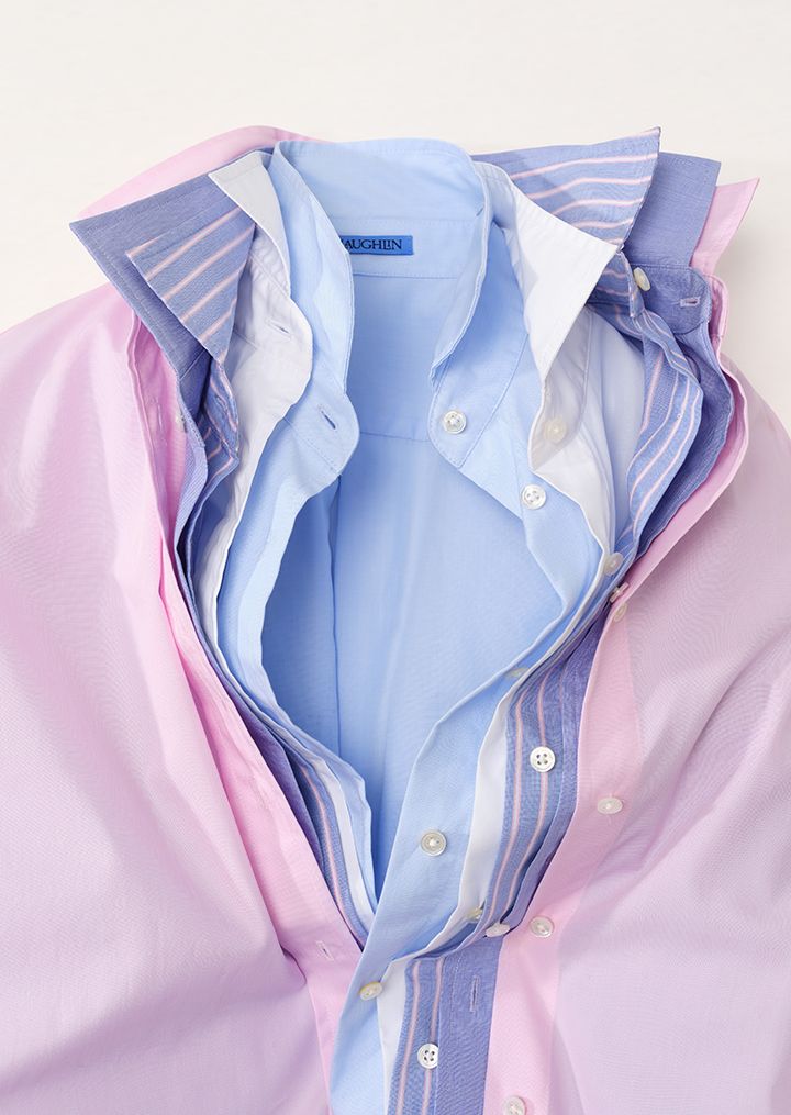Multiple unbuttoned collared shirts layered in pastel pink, blue, and striped patterns.