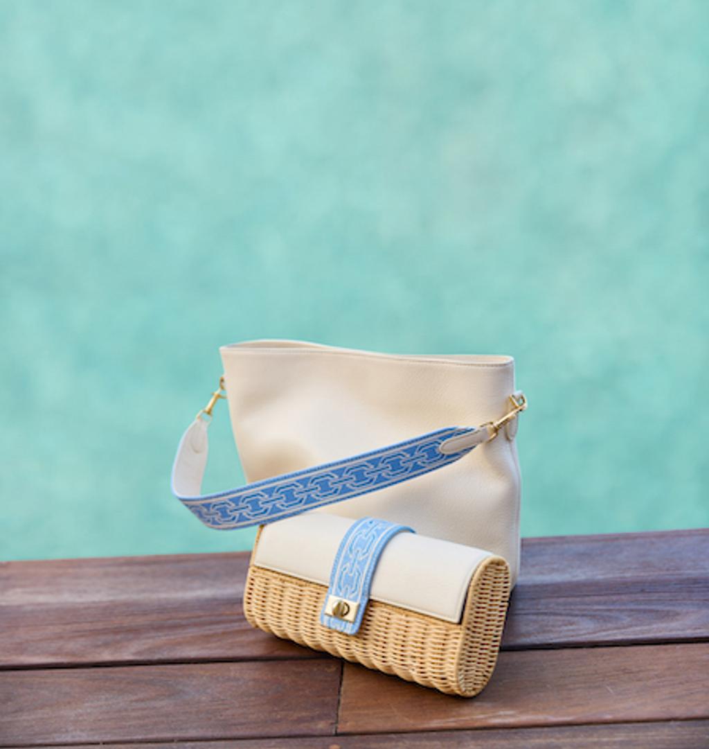 White bag with blue handle and wicker clutch