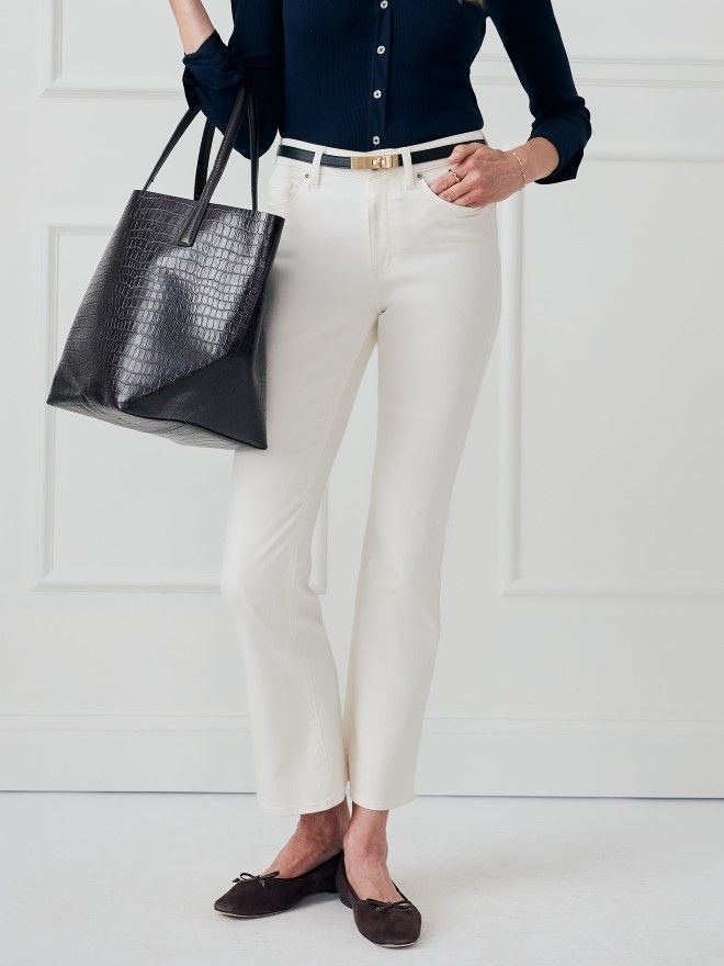 woman standing in egret white five pocket jeans with kick flare leg