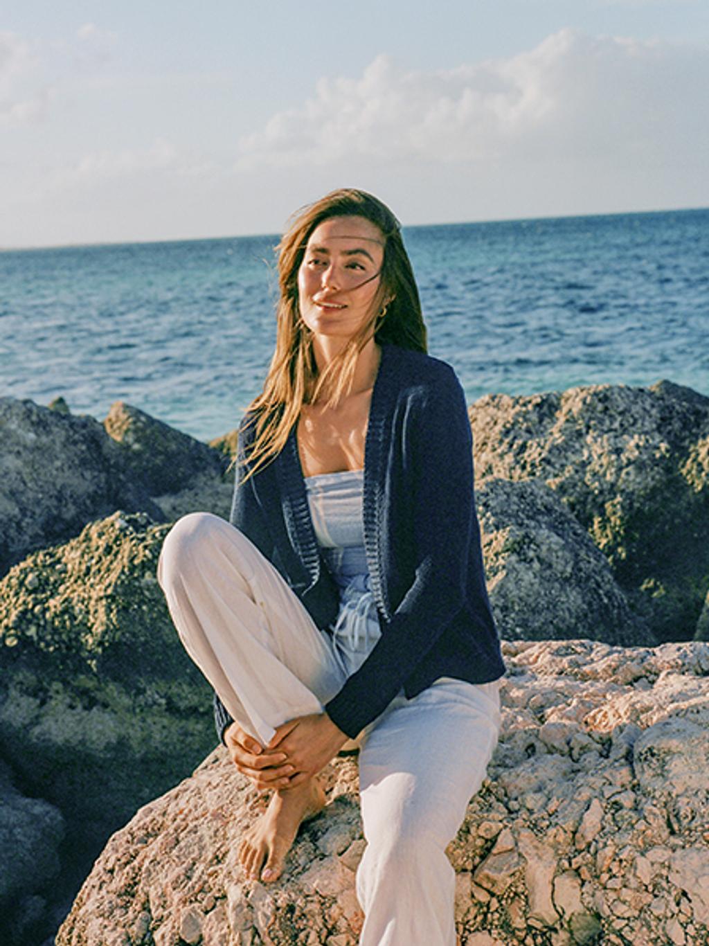Model wearing woven cardigan, scarf, and linen pants.