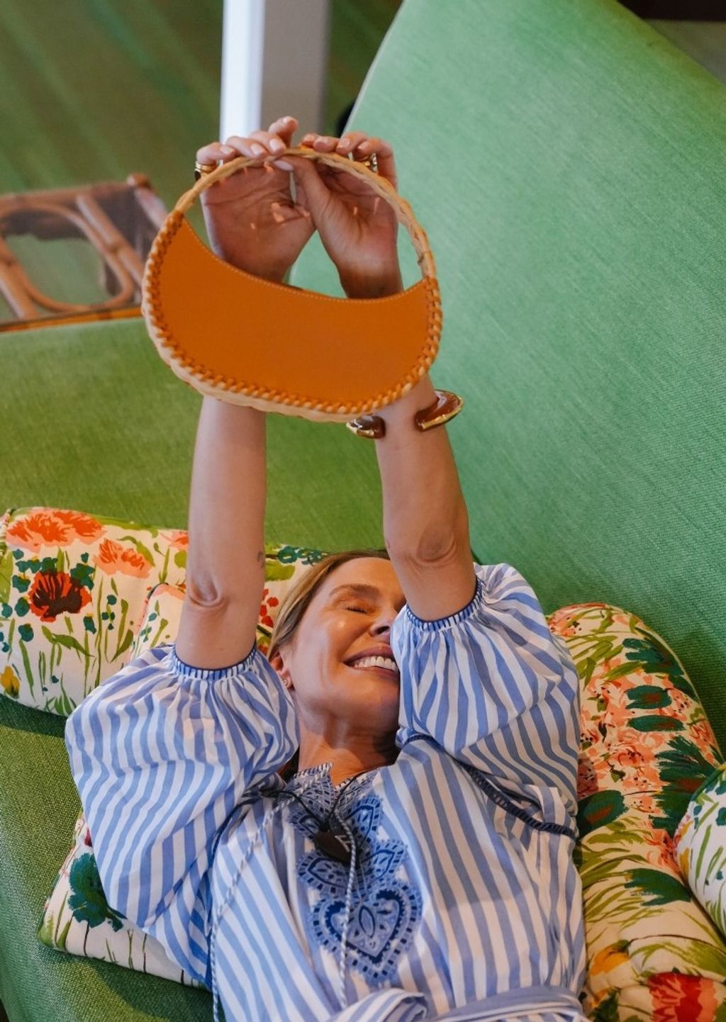 lady on couch holding up a handbag