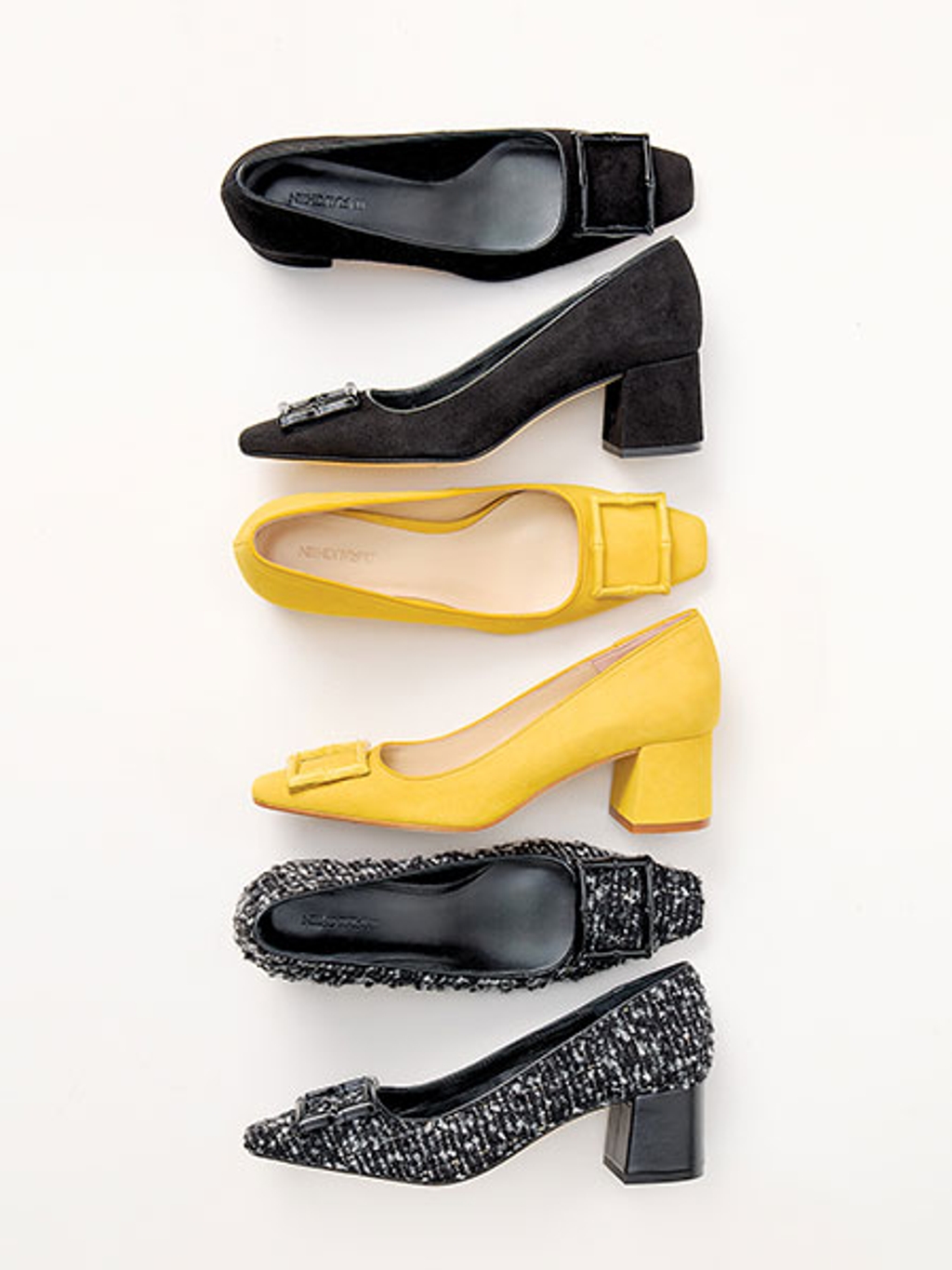 Three pairs of leather heels placed in a row, with two black pairs and one yellow pair.