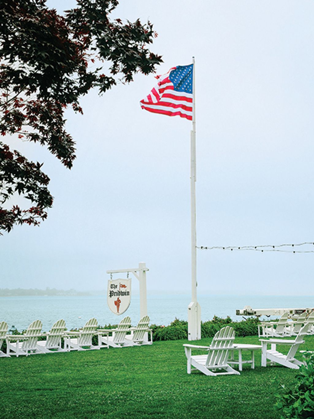 Shot of Adirondack chairs and American flag on Pridwin lawn