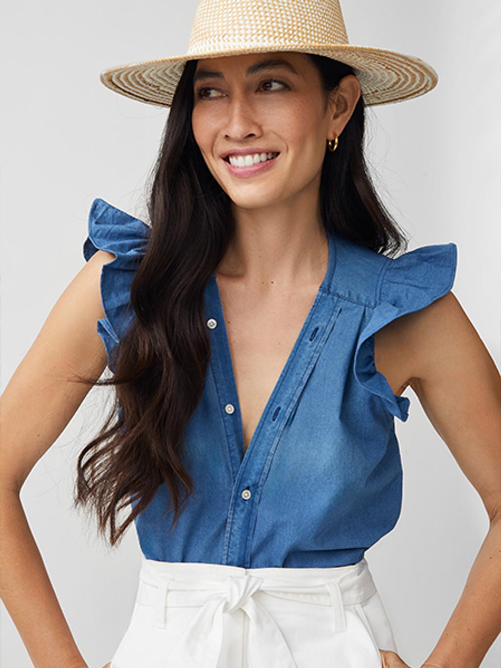 Model wearing limited-edition J.McLaughlin x KMJ shirt with white pants and straw hat.