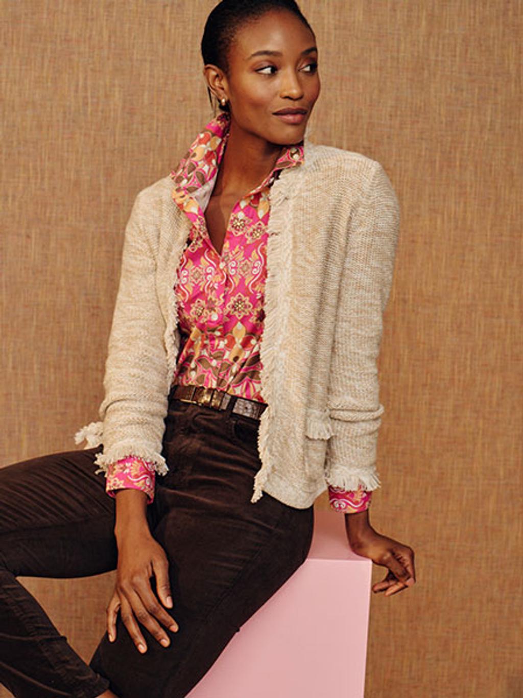 Model in a beige cardigan, patterned button down shirt, and black pants