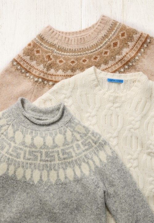 laydown of chunky fair isle and cable sweaters in soft winter palette