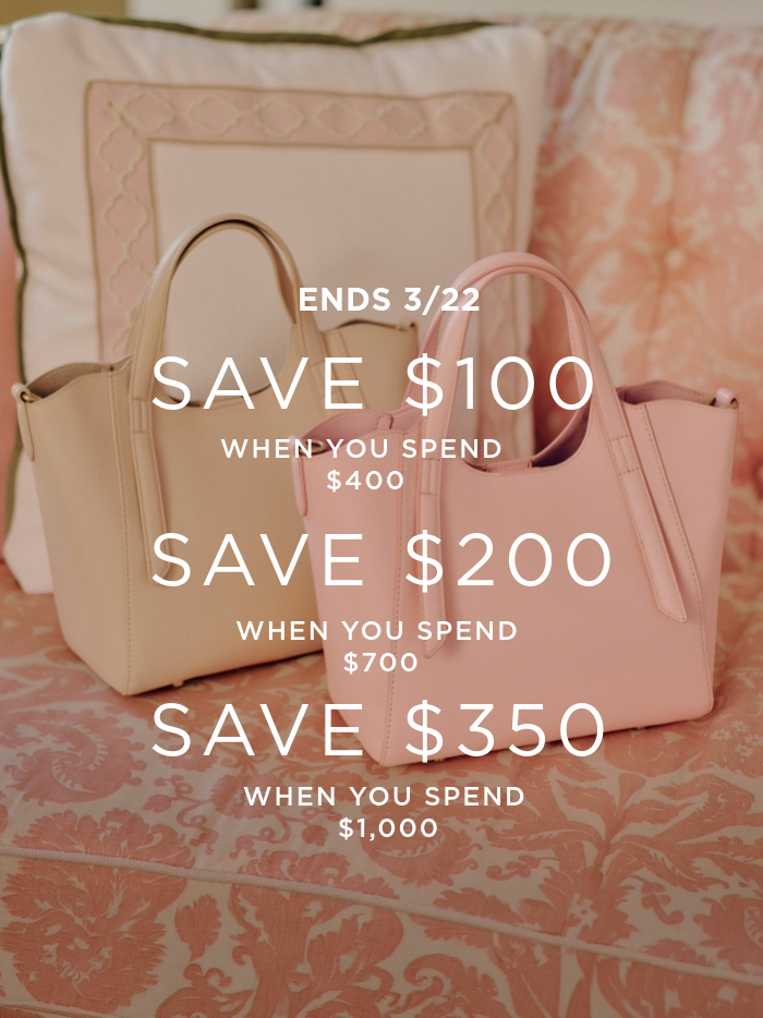 two womens smaller leather tote handbags on pink paisley pattern sofa