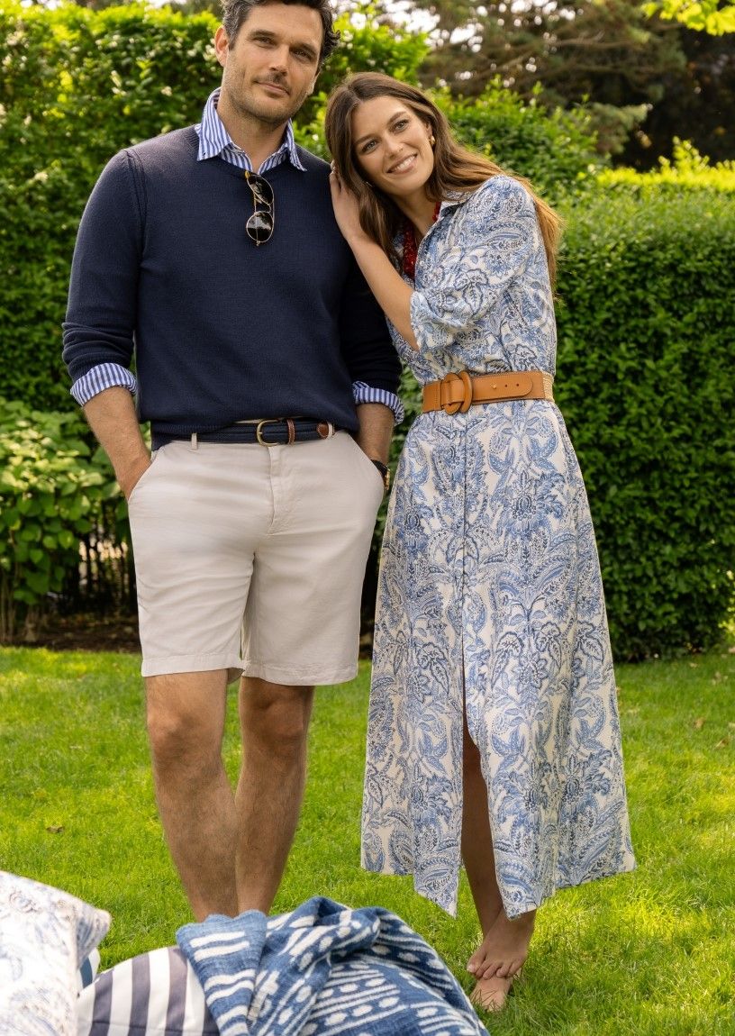 woman and man standing outside on a lawn, she is wearing blue paisley printed silky midi shirtdress