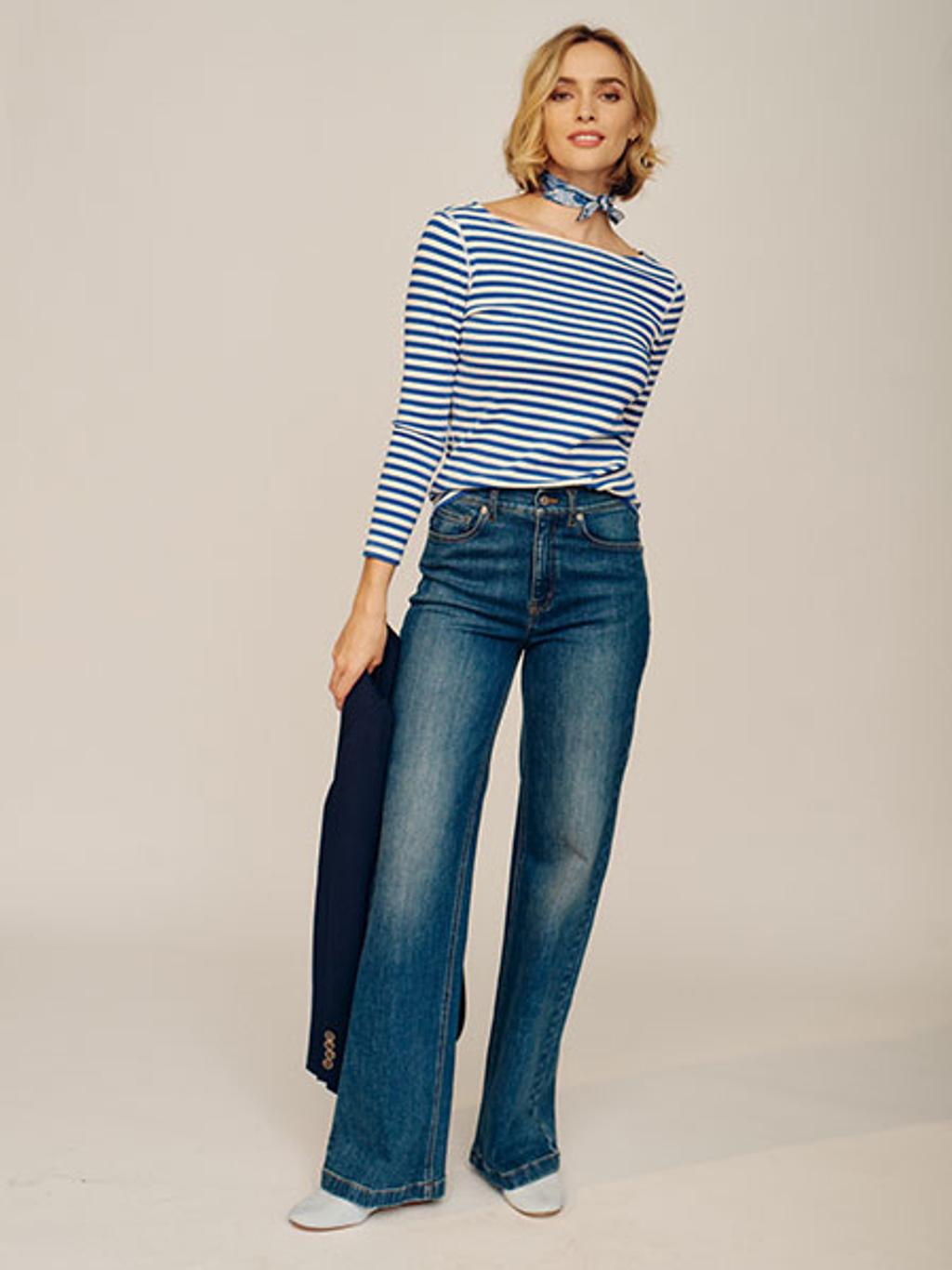Model wearing a striped blue and white long sleeve shirt and blue denim