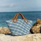 blue plaid raffia top handle tote on rock wall at beach