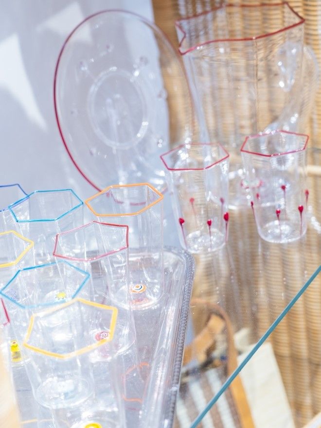 close up image of different murano glassware on a glass display shelf