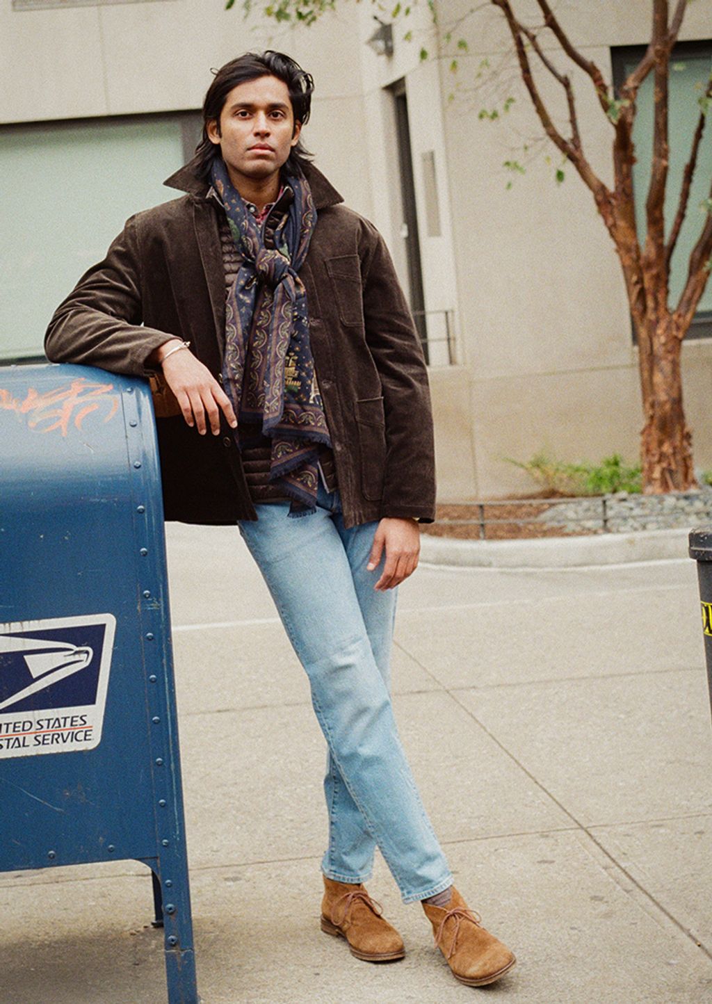 Male model modeling wearing button down shirt with sweater around shoulders 