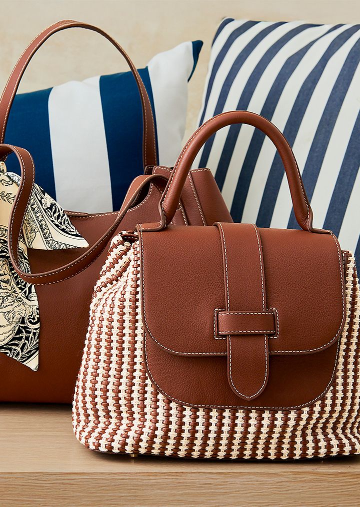 Close up image of a leather woven top handle handbag.
