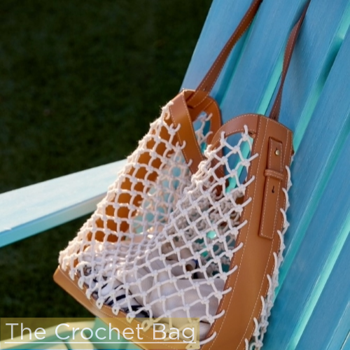 brown leather tote bag with crochet body hanging off turquoise Adirondack chair
